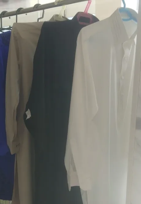 Stitched kameez hanging on the rail inside the shop